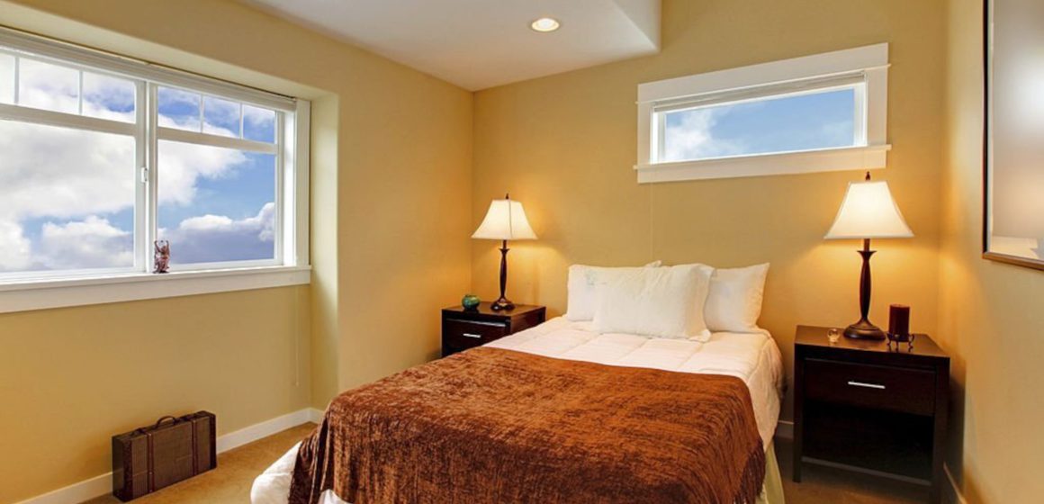 Bedroom with yellow mustard paint and brown bedding