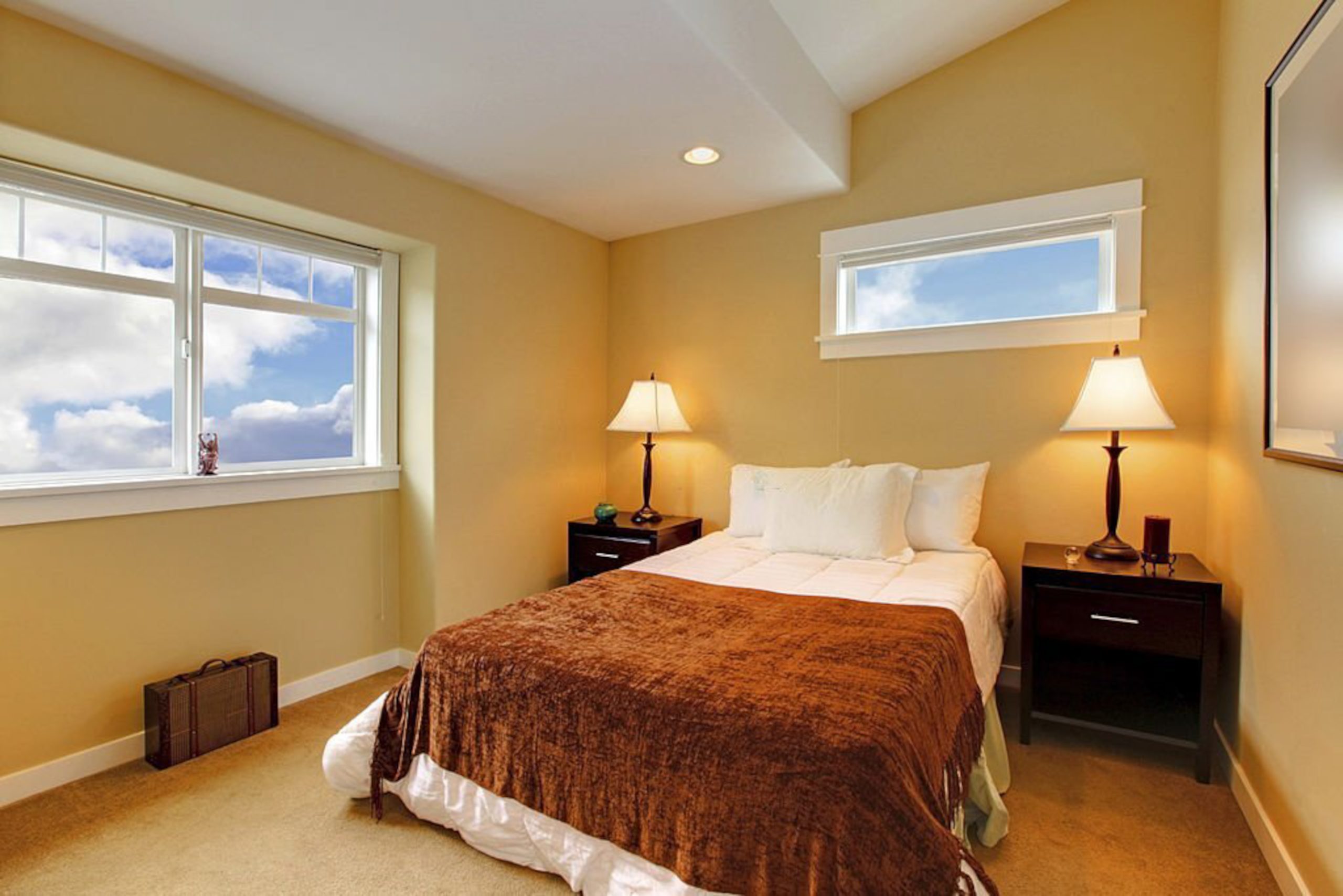 Bedroom with yellow mustard paint and brown bedding