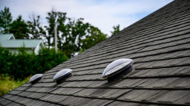 Dome shaped solar tube skylight on asphalt shingle roof