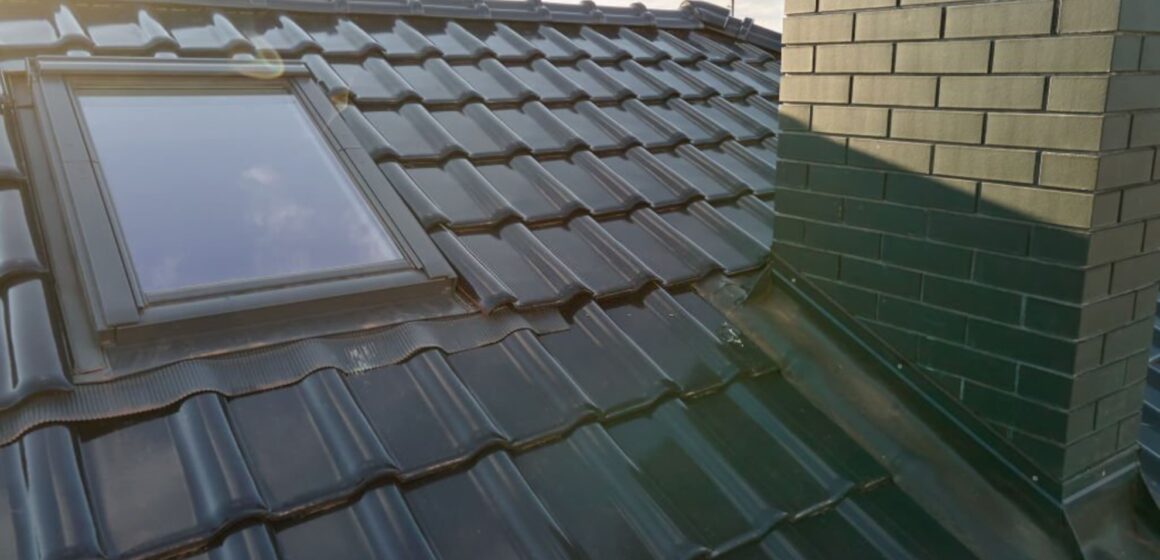 Closeup of attic window and brick chimney on house roof top covered with ceramic shingles(2)