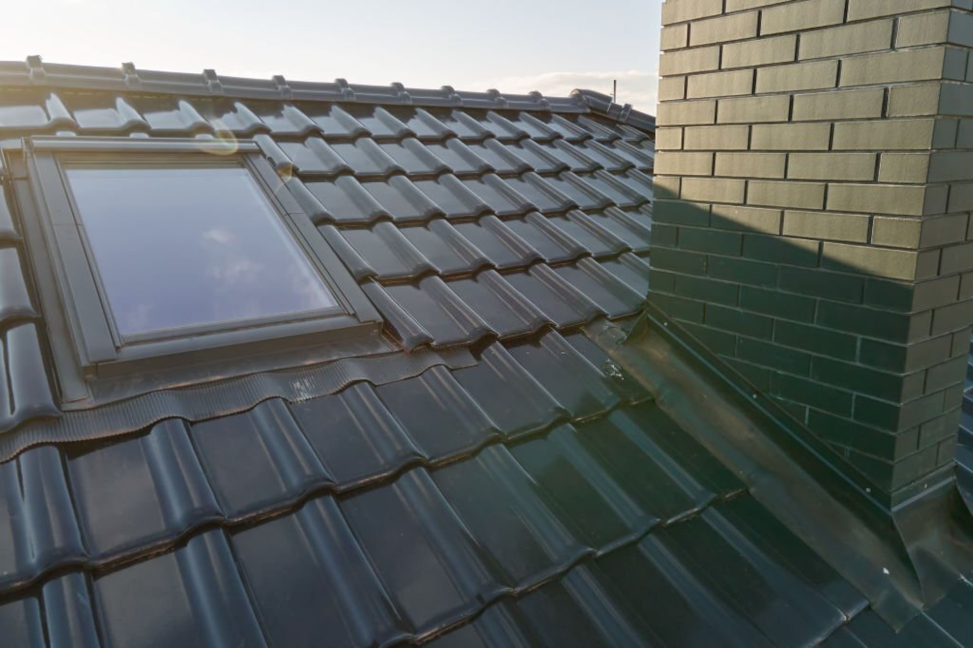 Closeup of attic window and brick chimney on house roof top covered with ceramic shingles(2)