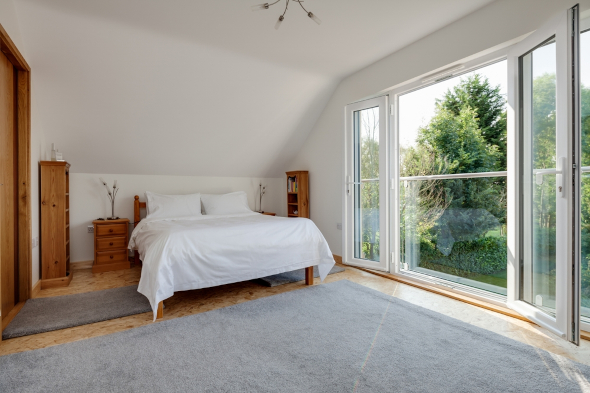 Furnished bright sunlit bedroom with pine furniture and open upvc double glazed doors to juliet balcony